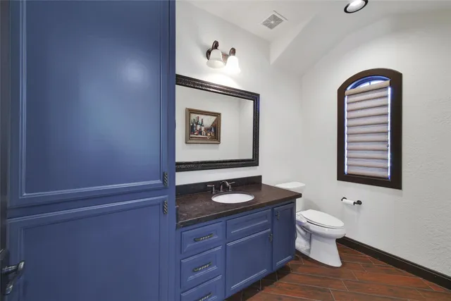 a bathroom with a toilet a sink and mirror