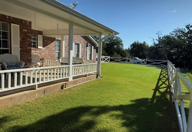 a view of a house with backyard and sitting area