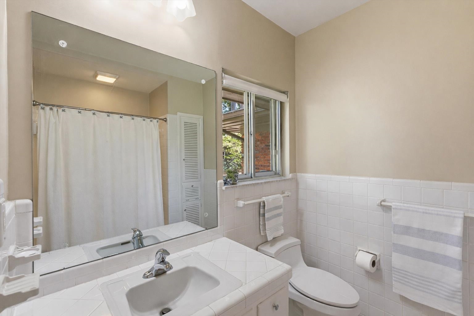 140 South Grove Park Road Memphis, TN 38117 - Photo 31 of 40 Bathroom with vanity, curtained tub/shower, a tile wainscoted wall, and tile walls