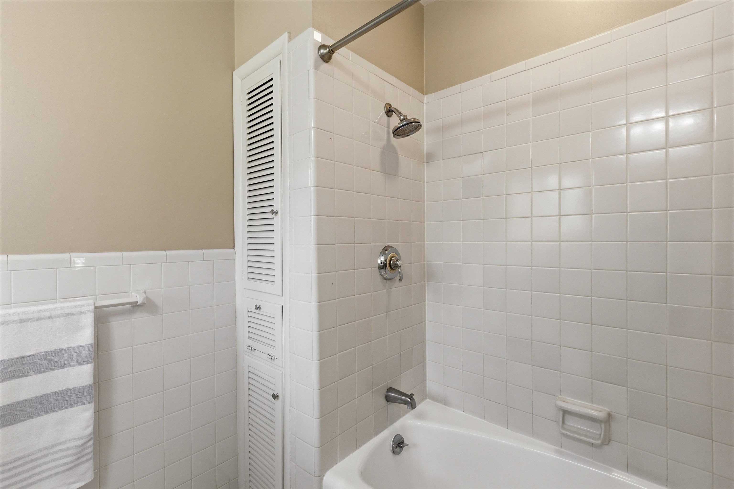 140 South Grove Park Road Memphis, TN 38117 - Photo 32 of 40 Full bath featuring a linen cupboard, shower/tub combination, tile walls, and wainscoting