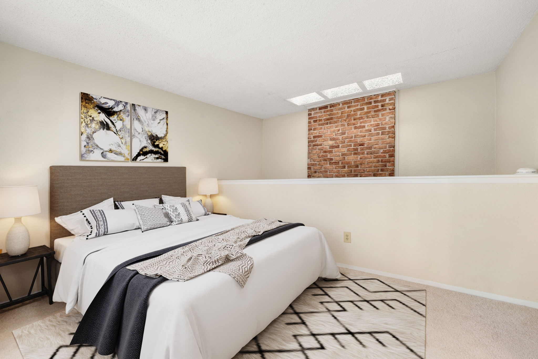 3200 South Gessner Road, Unit 228 Houston, TX 77063 - Photo 12 of 18 This unique secondary bedroom features plush carpet, a charming exposed brick accent wall, and a skylight window bringing in natural light, a cozy and character-filled space perfect for guests or family! *Virtually Staged
