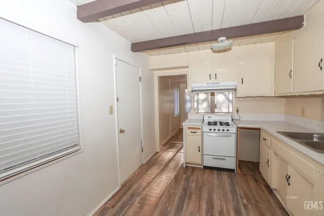 a kitchen with white cabinets and white appliances