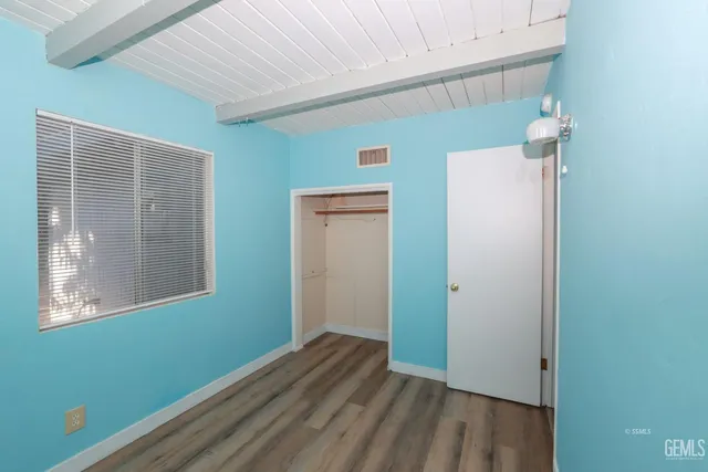 a view of a room that has wooden floor and a window
