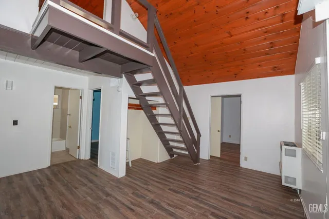 an empty room with wooden floor and stairs