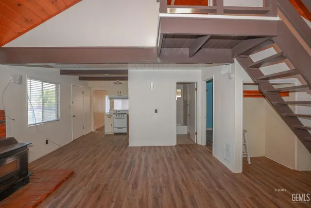 a view of a hallway with wooden floor and staircase