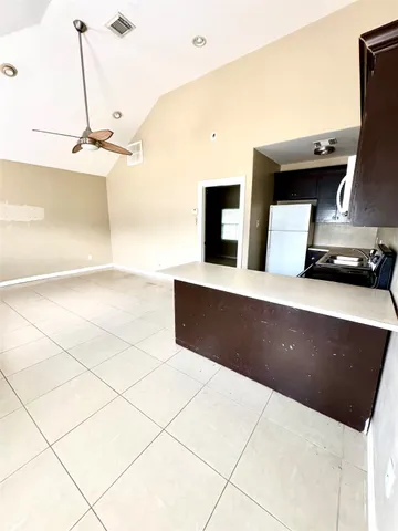 a kitchen with granite countertop a sink a counter top space and cabinets
