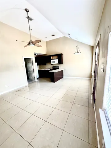 en empty room with windows and ceiling fan