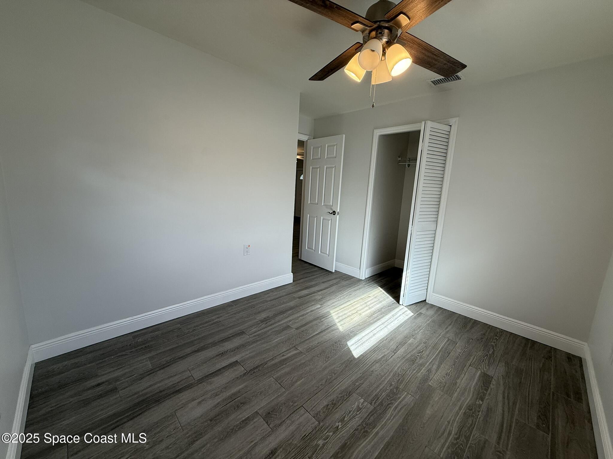 2801 Lorna Drive Melbourne, FL 32935 - Photo 11 of 25 a view of empty room with wooden floor and fan