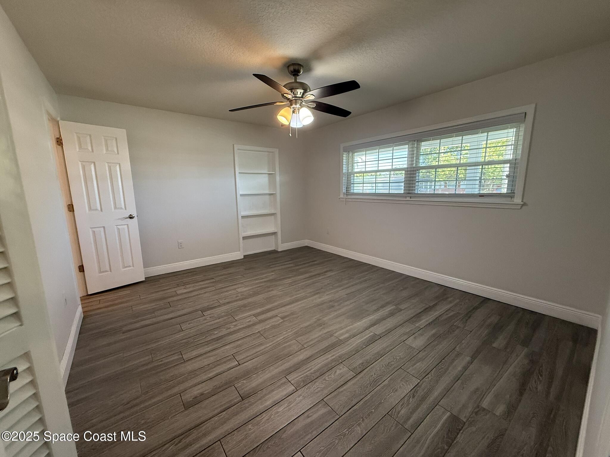 2801 Lorna Drive Melbourne, FL 32935 - Photo 5 of 25 wooden floor in an empty room with a window