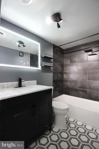 a bathroom with a sink a toilet a mirror and shower