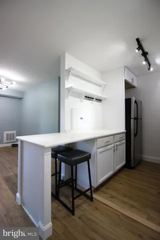 a kitchen with a sink cabinets and wooden floor