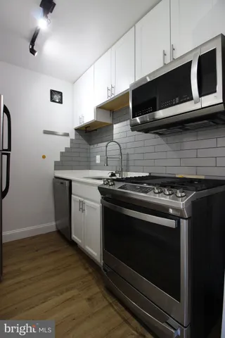 a kitchen with stainless steel appliances a stove a microwave and cabinets
