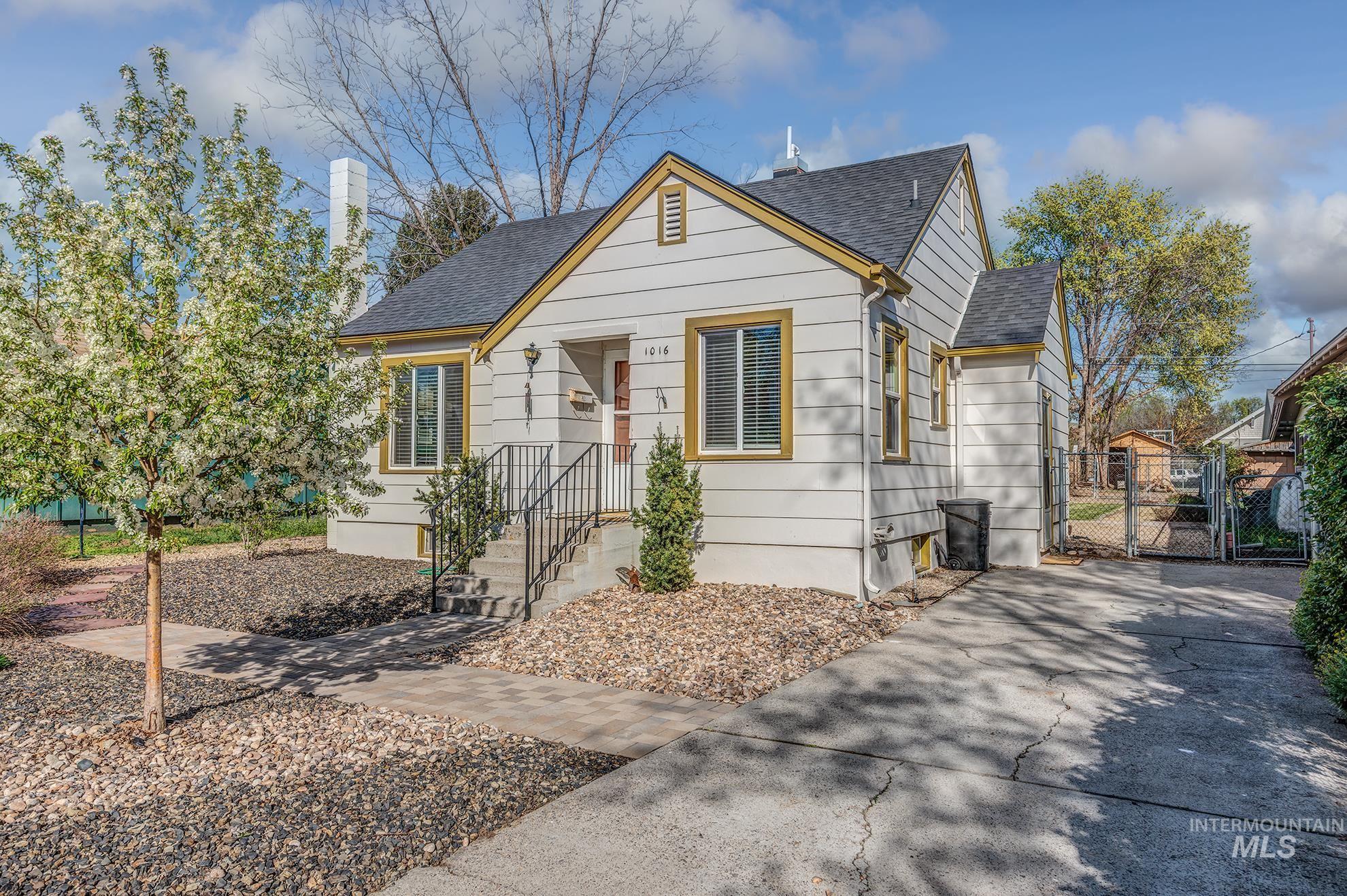 Bungalow-style house featuring a shingled roof, a gate, and a chimney