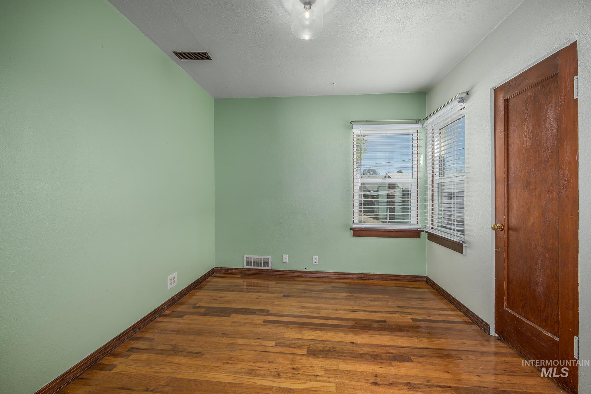 1016 West 5th Street Weiser, ID 83672 - Photo 11 of 36 Unfurnished bedroom featuring dark wood-style flooring and baseboards