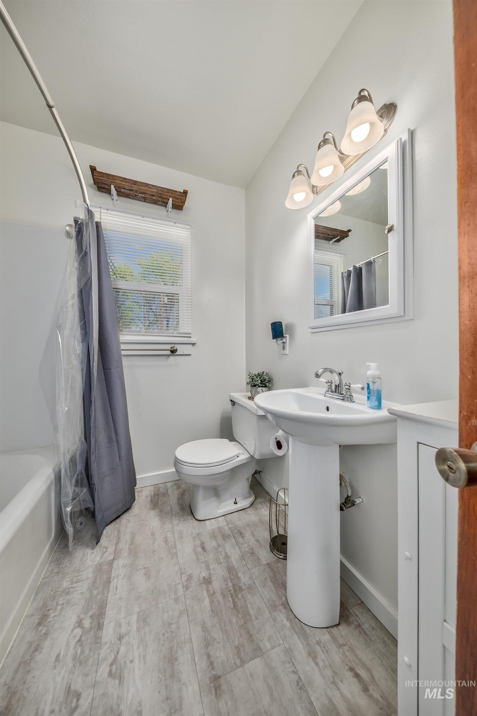 1016 West 5th Street Weiser, ID 83672 - Photo 12 of 36 Bathroom with light wood finished floors and shower / tub combo