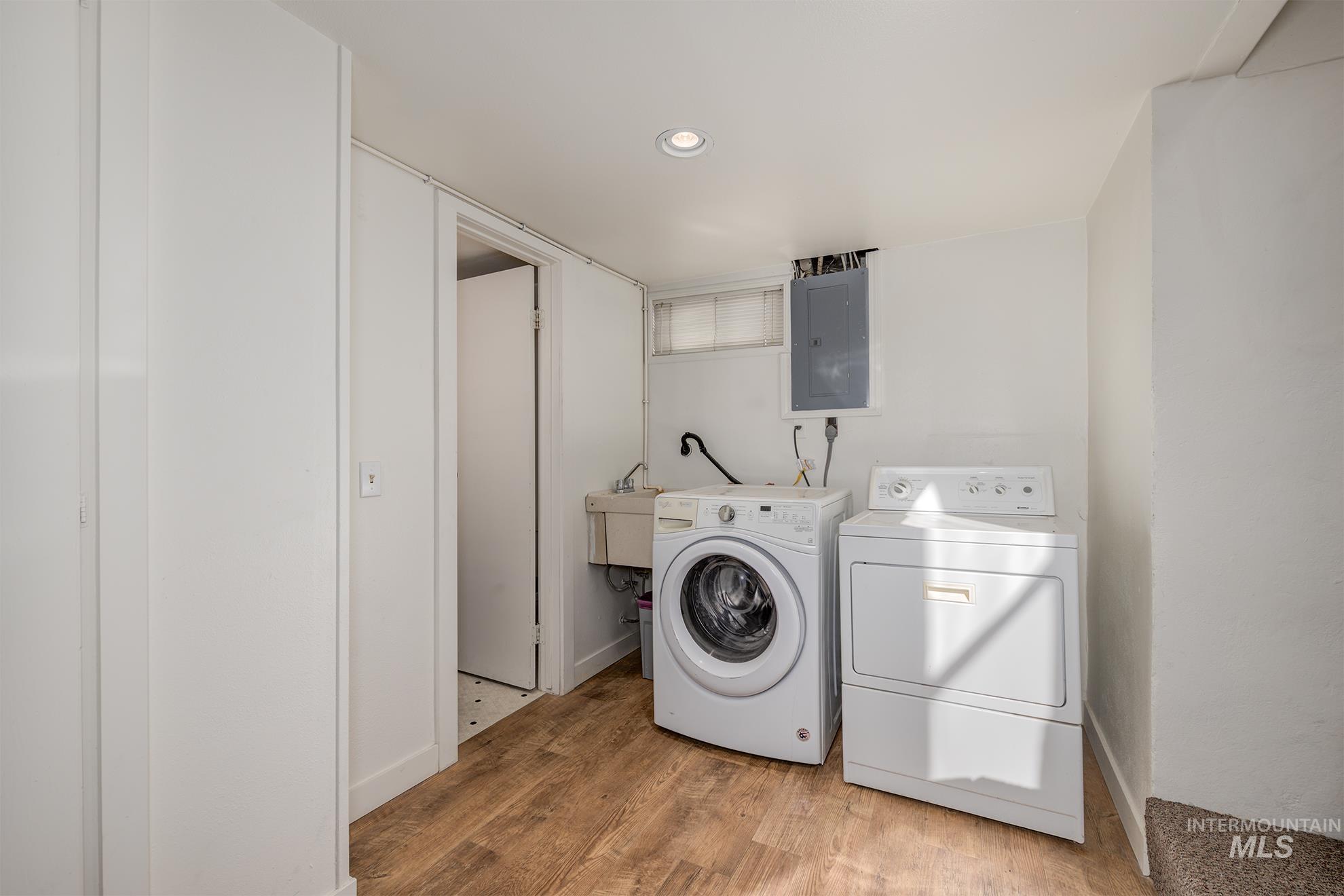 1016 West 5th Street Weiser, ID 83672 - Photo 16 of 36 Laundry area with electric panel, light wood-style floors, washer and clothes dryer, and recessed lighting