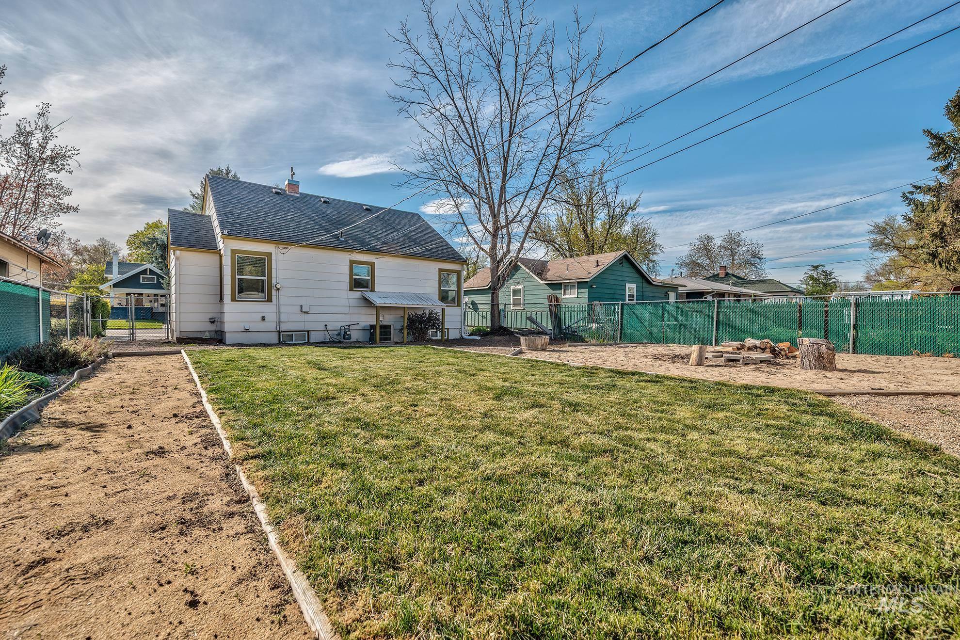 1016 West 5th Street Weiser, ID 83672 - Photo 33 of 36 Rear view of property featuring a fenced backyard, a patio area, a shingled roof, and a chimney