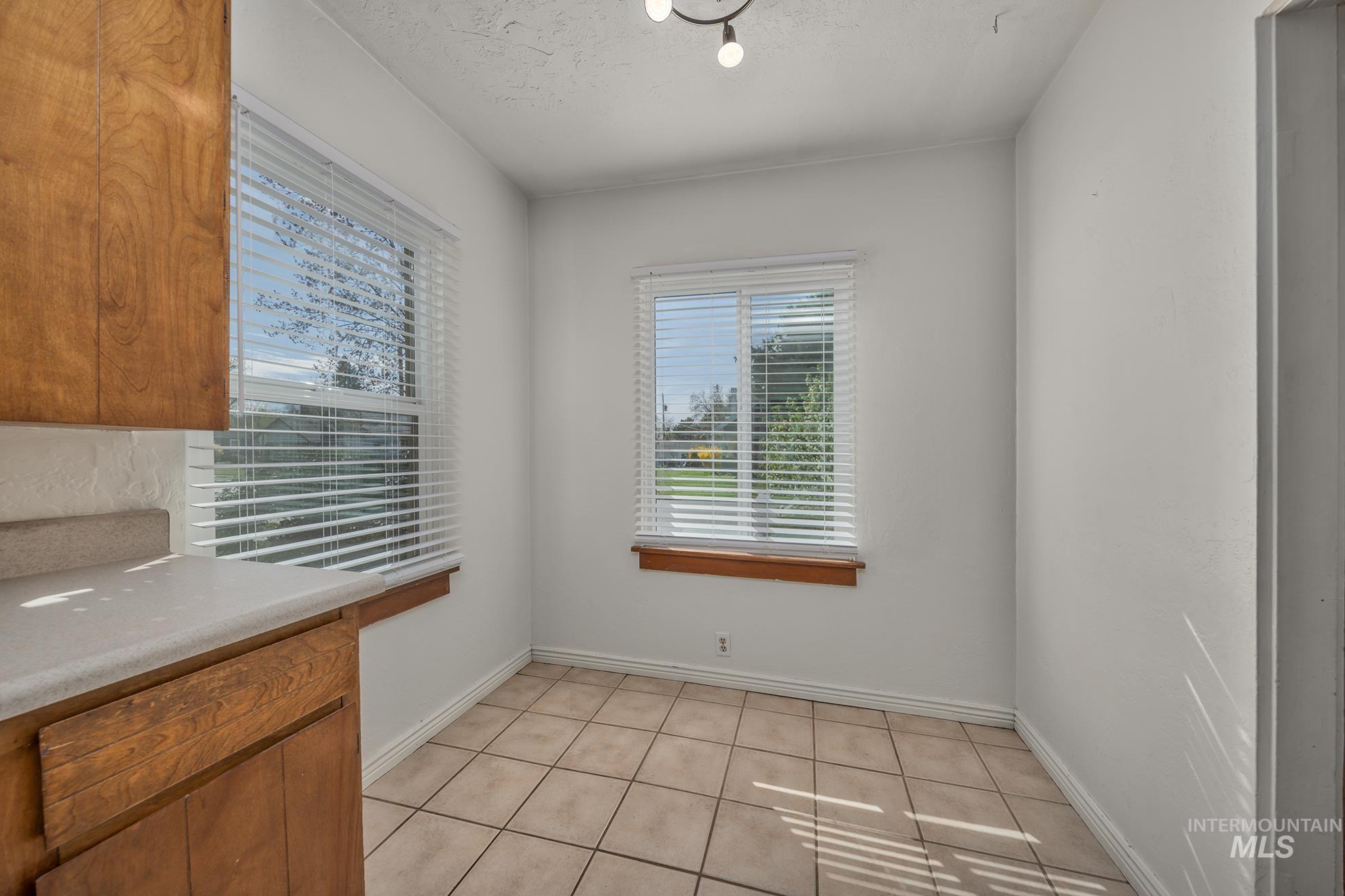 1016 West 5th Street Weiser, ID 83672 - Photo 5 of 36 Unfurnished dining area featuring light tile patterned floors and a textured ceiling
