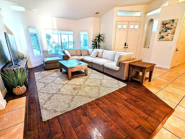 a living room with furniture a rug and a table