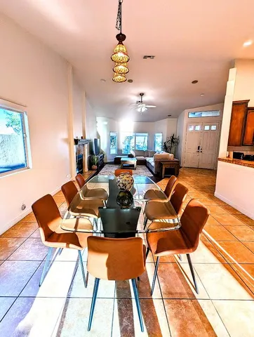 a living room with furniture a flat screen tv and a chandelier