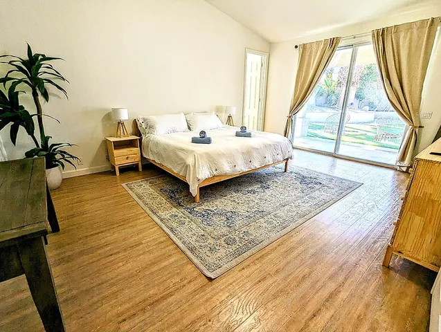 a bedroom with a bed and wooden floor