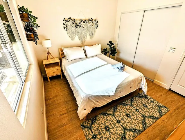 a bedroom with a bed and wooden floor