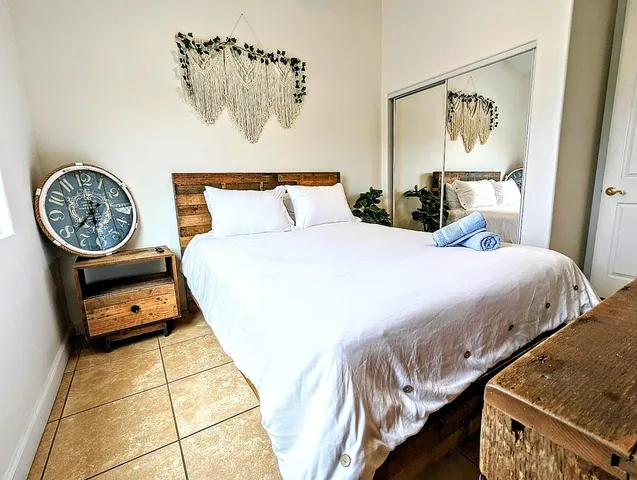 a bedroom with a bed a mirror and paintings on the wall