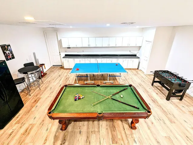 a room with pool table and windows