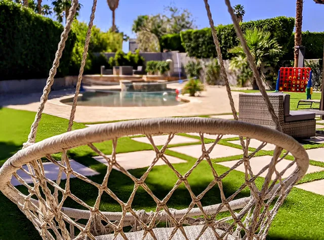 a view of a swimming pool with a patio and plants