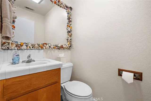 a bathroom with a sink a toilet and mirror