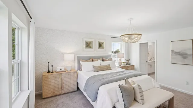 a bedroom with a bed a mirror on dresser and a window