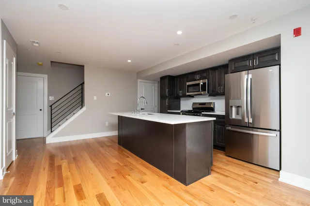 a kitchen with stainless steel appliances granite countertop a refrigerator and a stove top oven