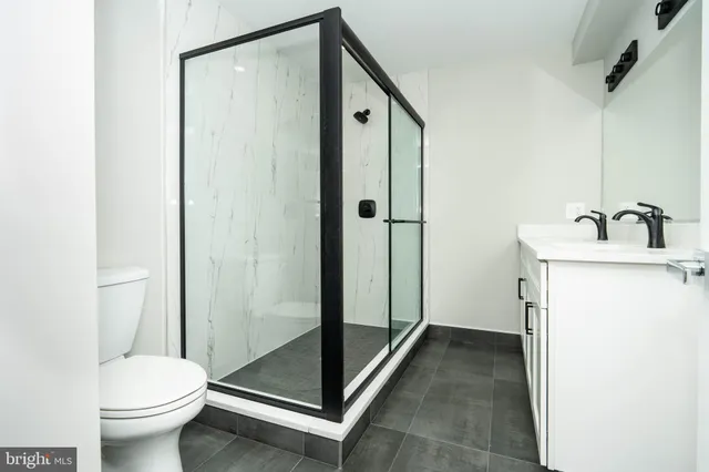 a bathroom with a granite countertop sink toilet and shower