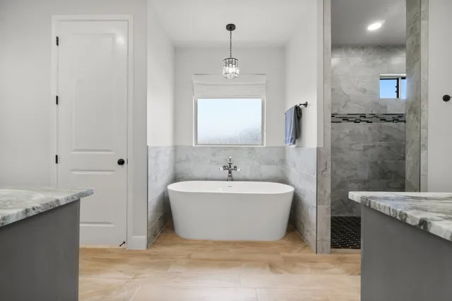 a spacious bathroom with a bathtub sink and mirror