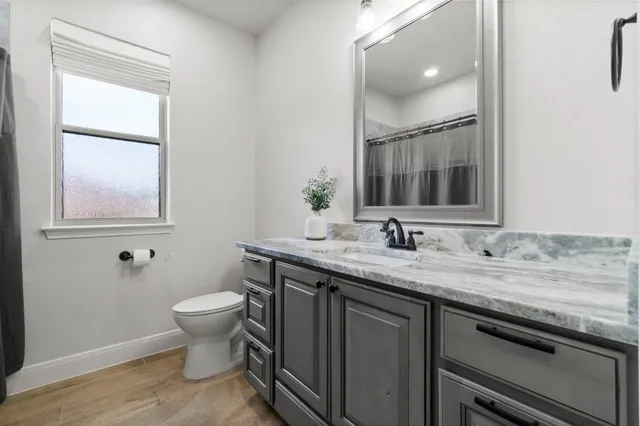 a bathroom with a granite countertop sink and a mirror