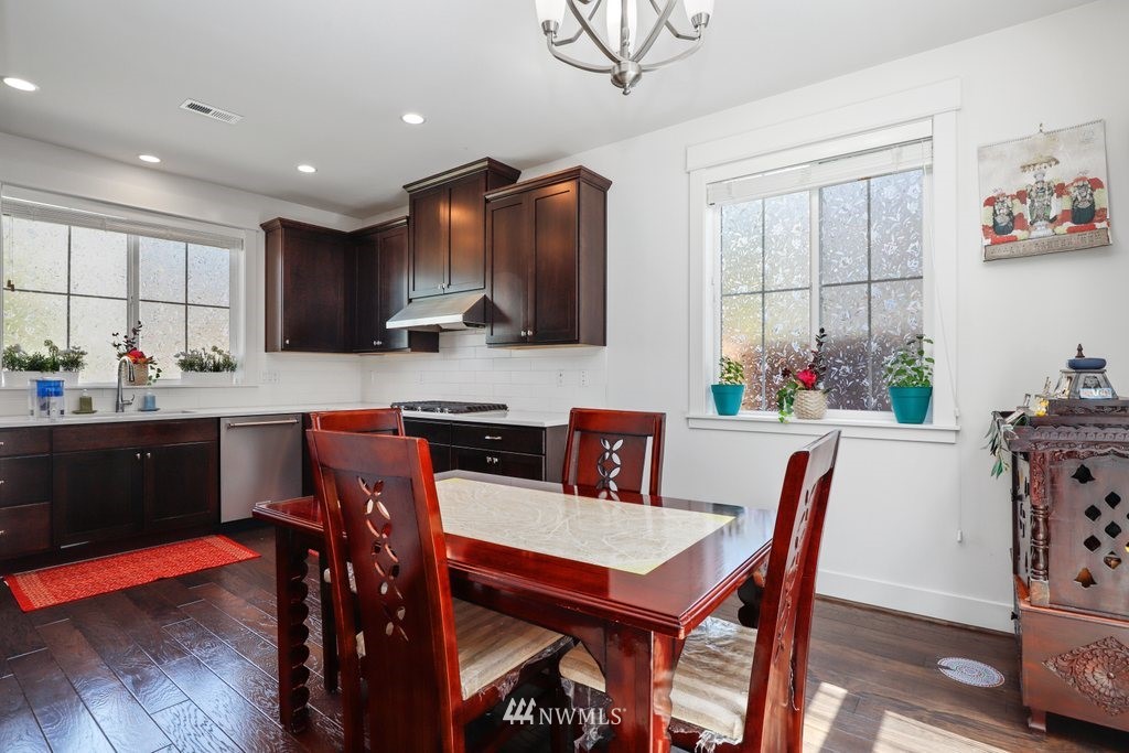 4606 187th Place Southeast Bothell, WA 98012 - Photo 9 of 40 a kitchen with granite countertop a dining table chairs and microwave