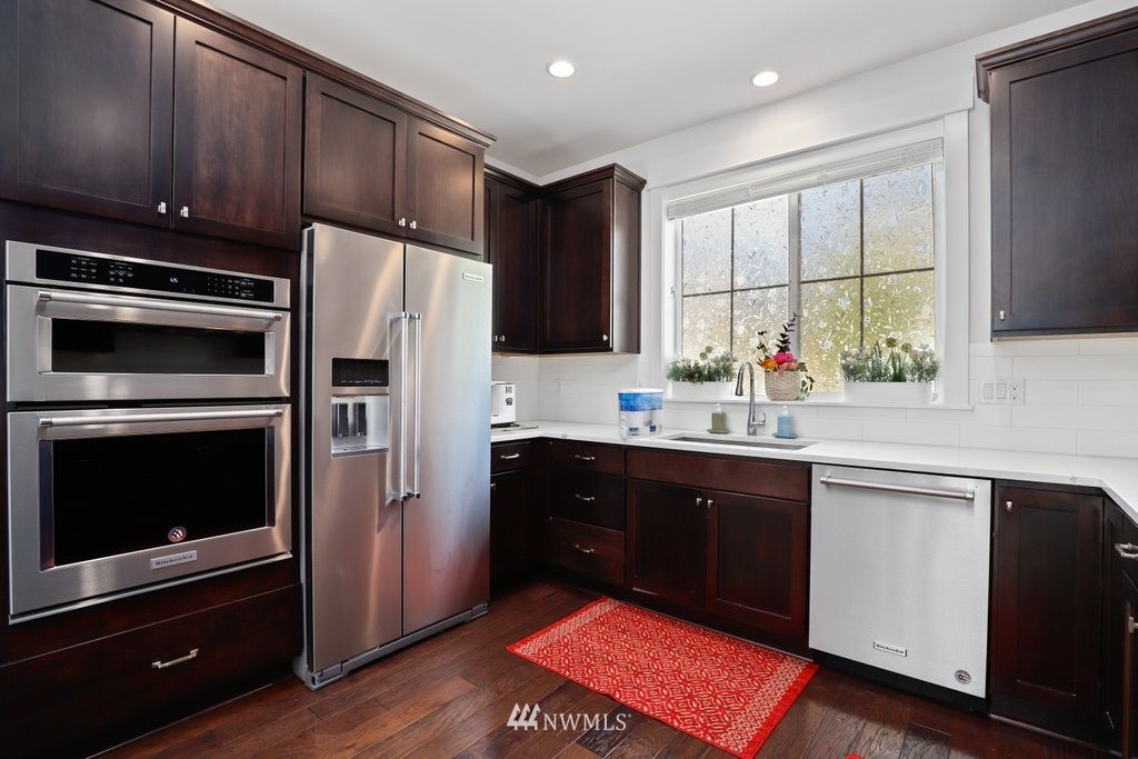 4606 187th Place Southeast Bothell, WA 98012 - Photo 10 of 40 a kitchen with stainless steel appliances kitchen island granite countertop a refrigerator stove and sink