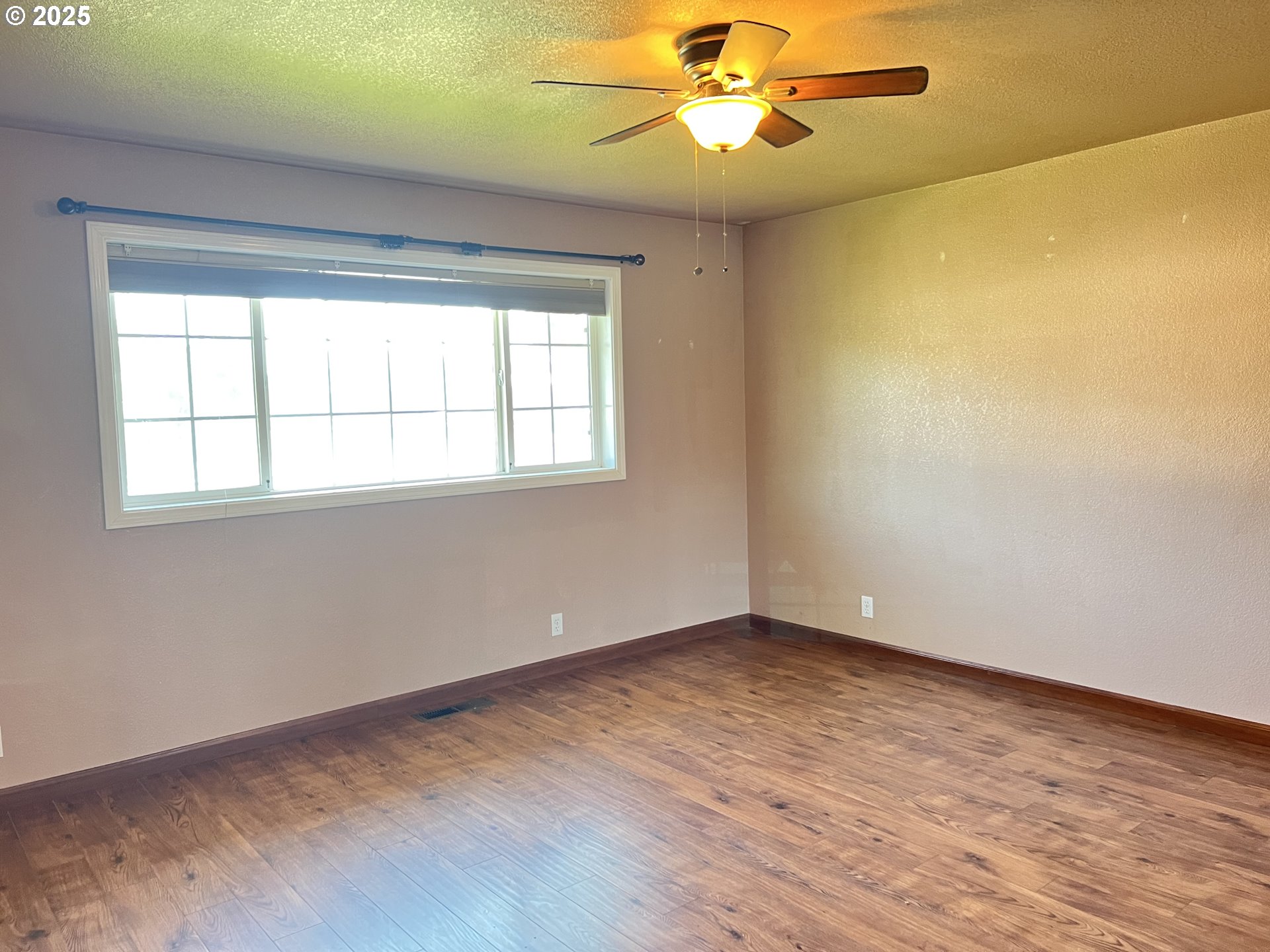 790 West Division Avenue Hermiston, OR 97838 - Photo 12 of 26 a view of an empty room with wooden floor and a window