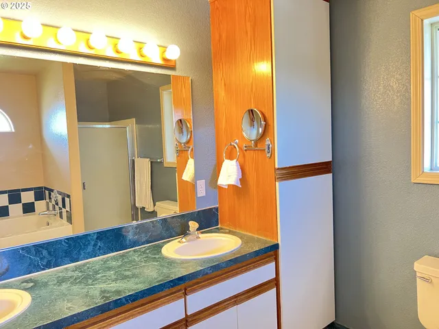 a bathroom with a granite countertop toilet sink and mirror