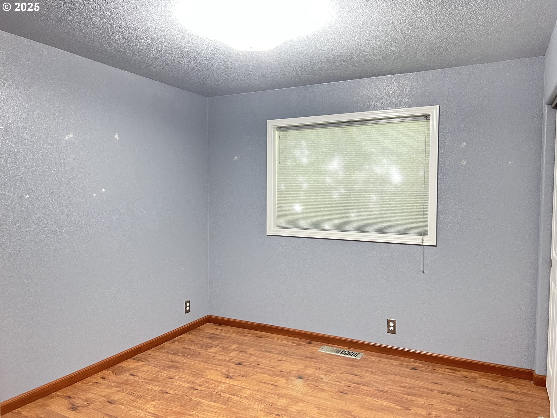790 West Division Avenue Hermiston, OR 97838 - Photo 9 of 26 an empty room with wooden floor and windows