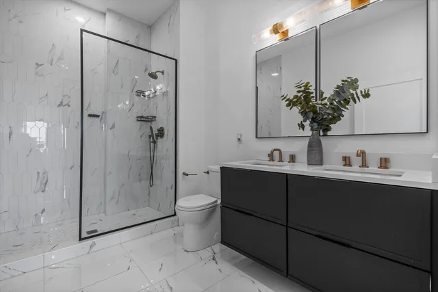 a bathroom with a granite countertop sink toilet and shower