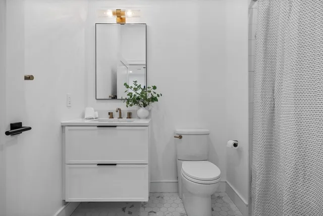 a bathroom with a sink toilet and mirror