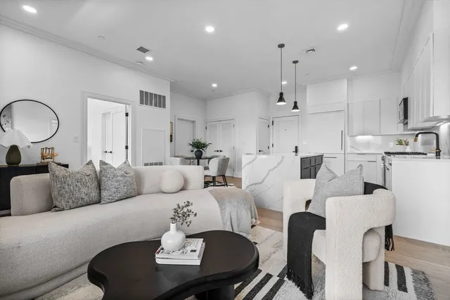a living room with furniture kitchen view and a chandelier