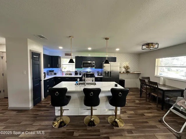 a living room with lots of furniture and kitchen view
