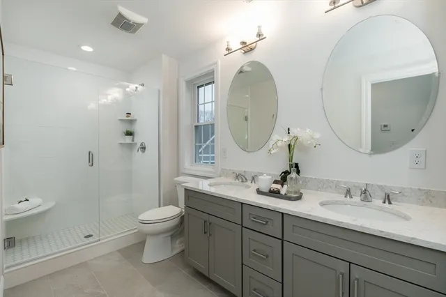 a bathroom with a granite countertop double vanity sink and a mirror