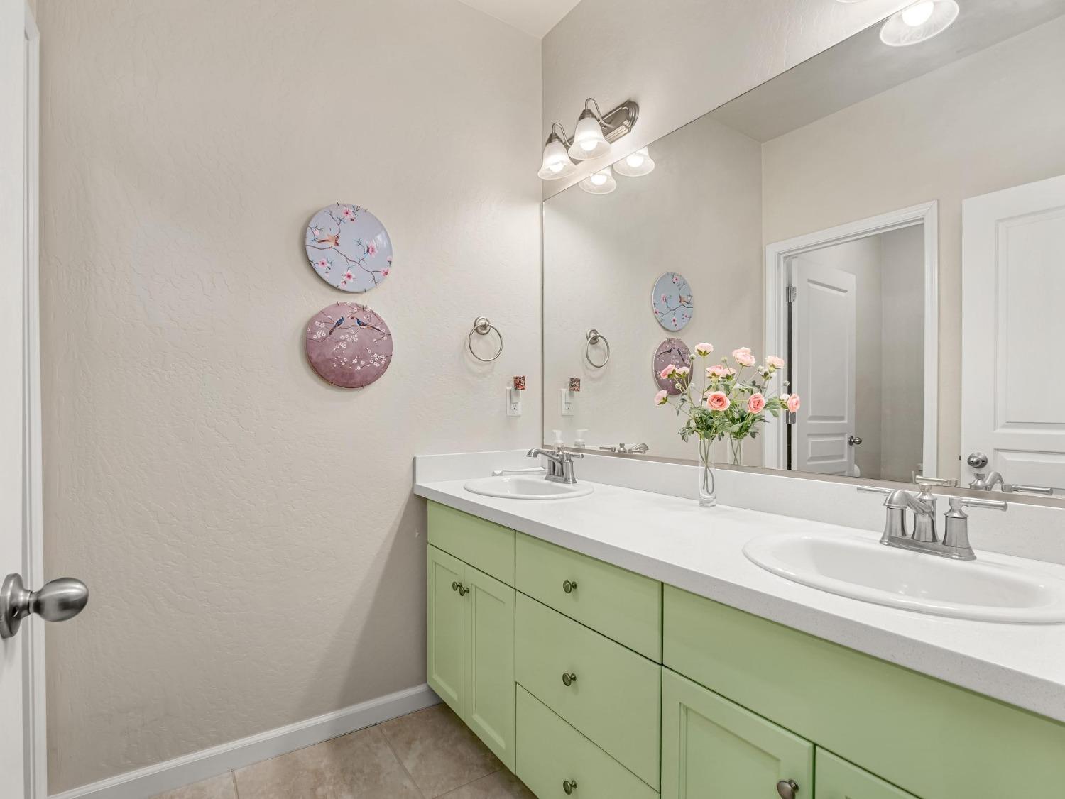 1012 Las Rosas Avenue Clovis, CA 93619 - Photo 14 of 36 a bathroom with a double vanity sink and a mirror