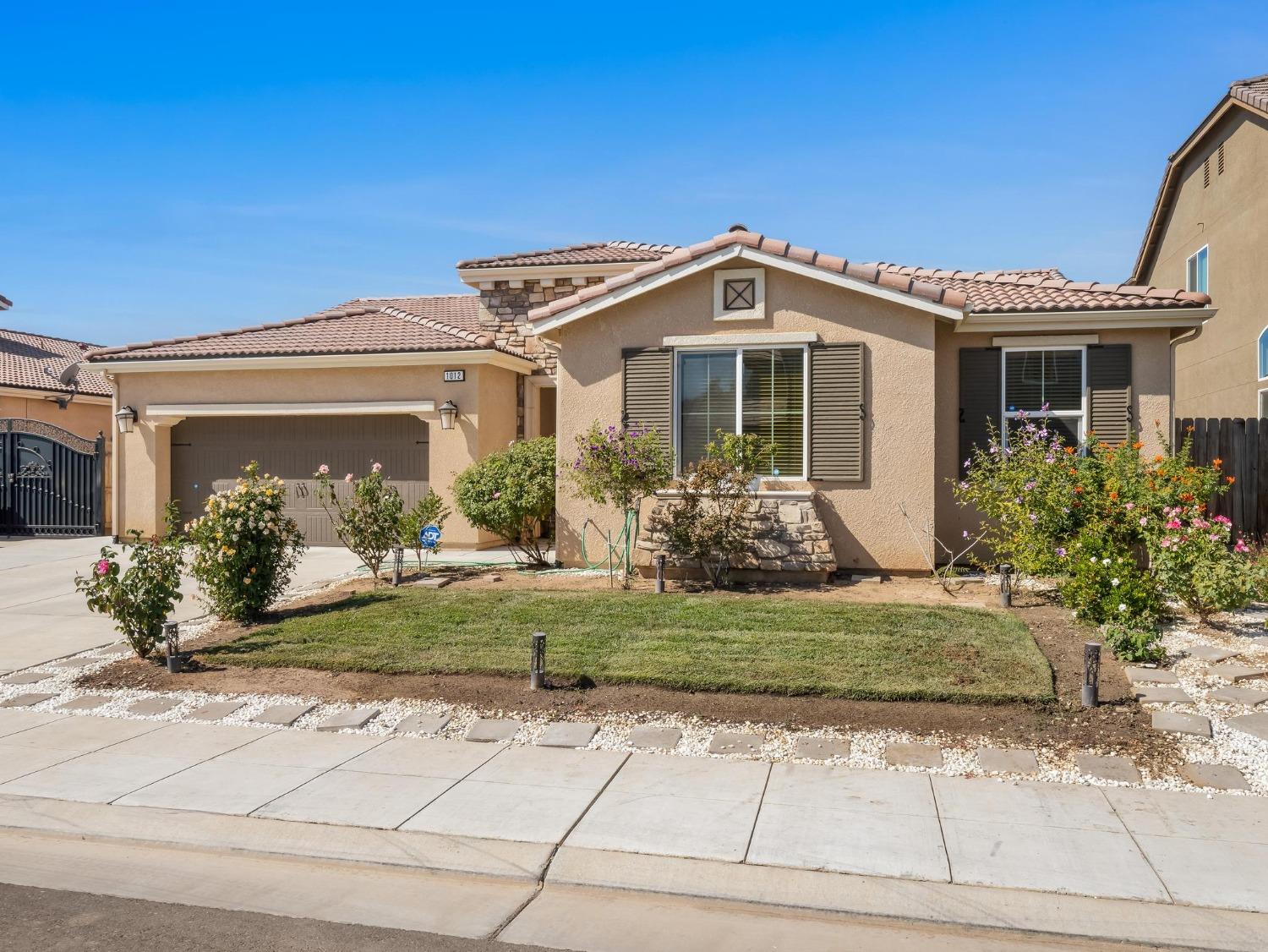 1012 Las Rosas Avenue Clovis, CA 93619 - Photo 2 of 36 a front view of a house with garden