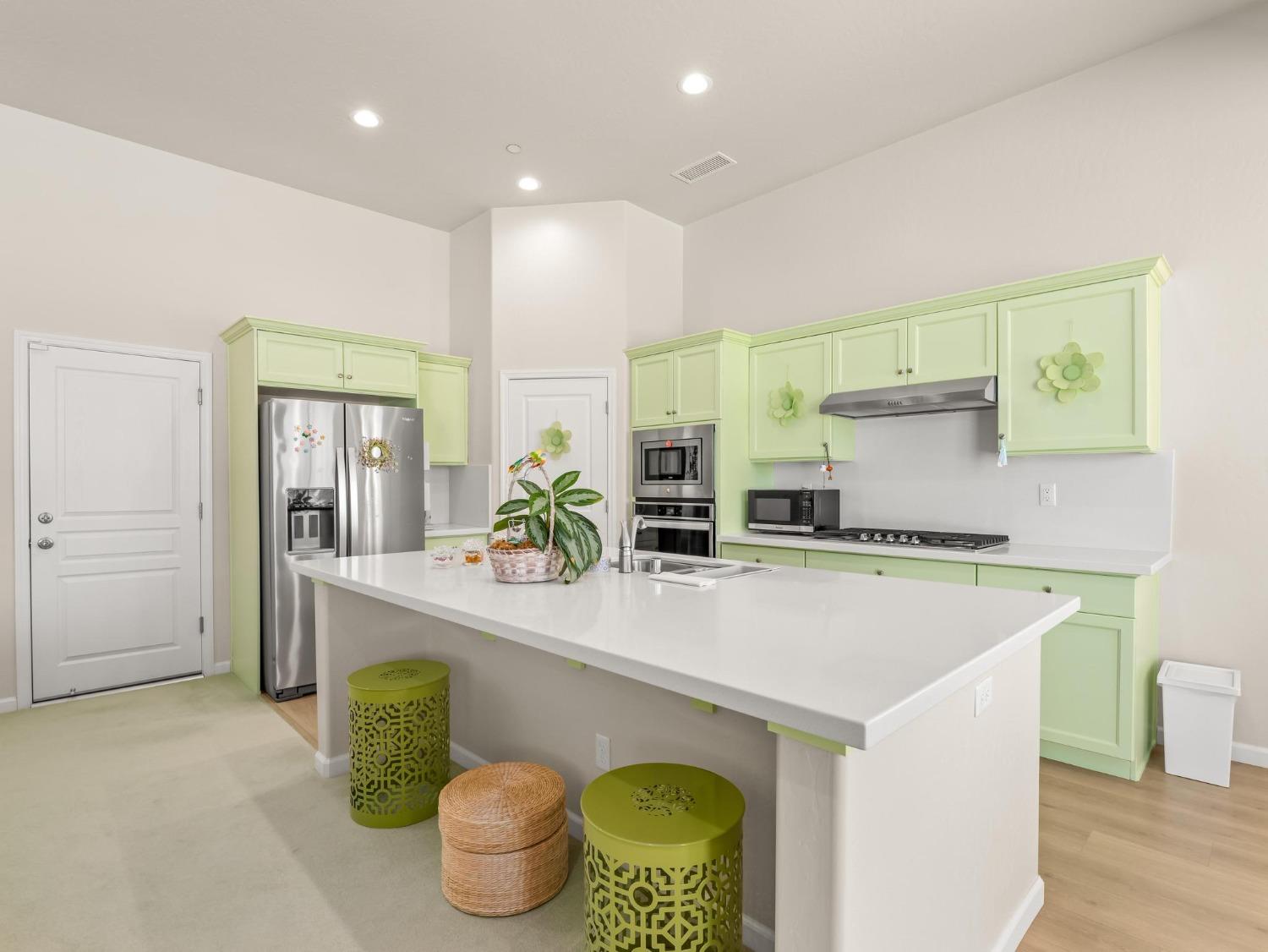 1012 Las Rosas Avenue Clovis, CA 93619 - Photo 9 of 36 a kitchen with kitchen island a stove a sink and a refrigerator