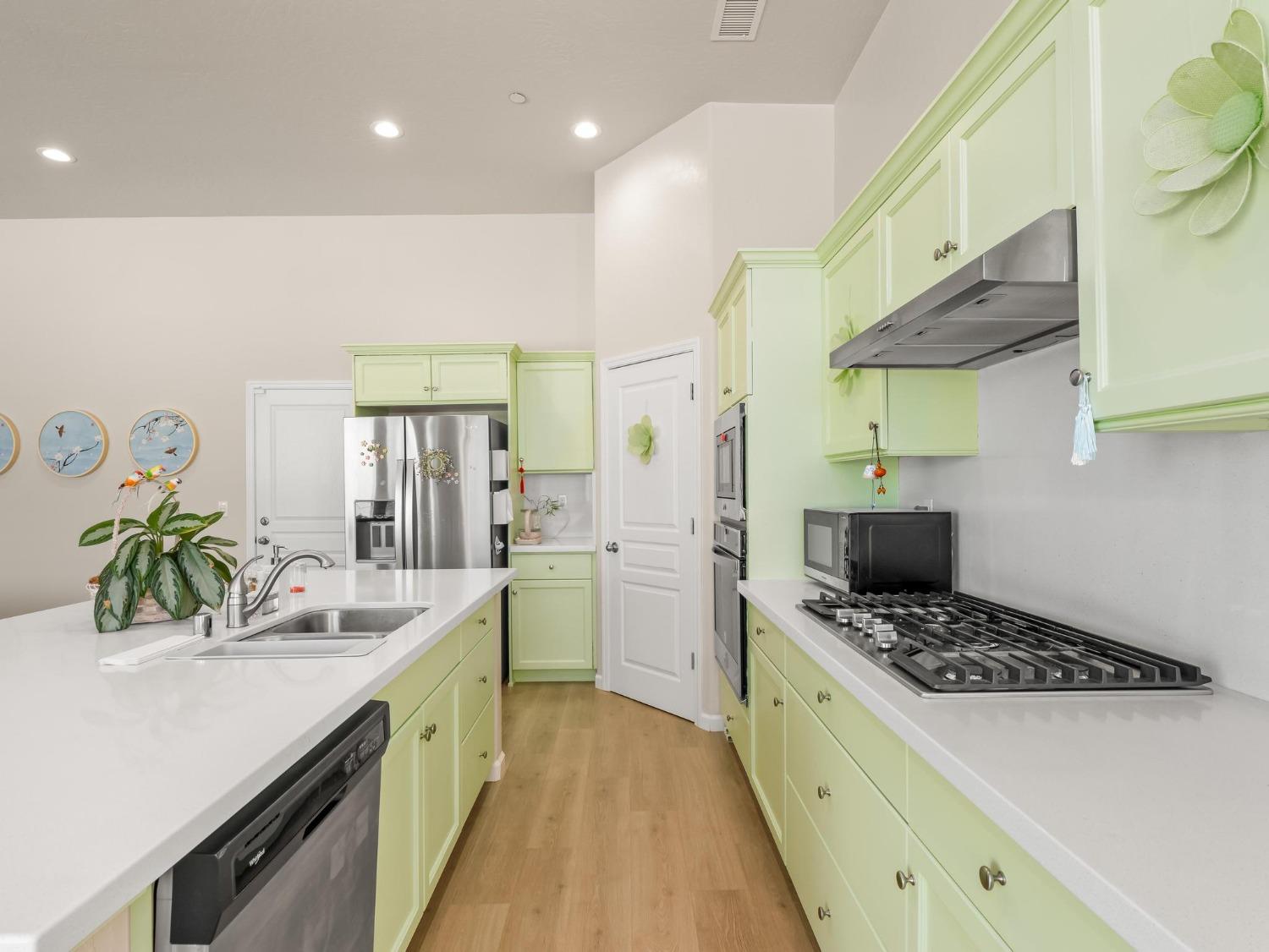 1012 Las Rosas Avenue Clovis, CA 93619 - Photo 10 of 36 a kitchen with a sink a stove cabinets and wooden floor