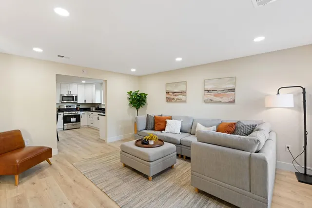 a living room with furniture and wooden floor